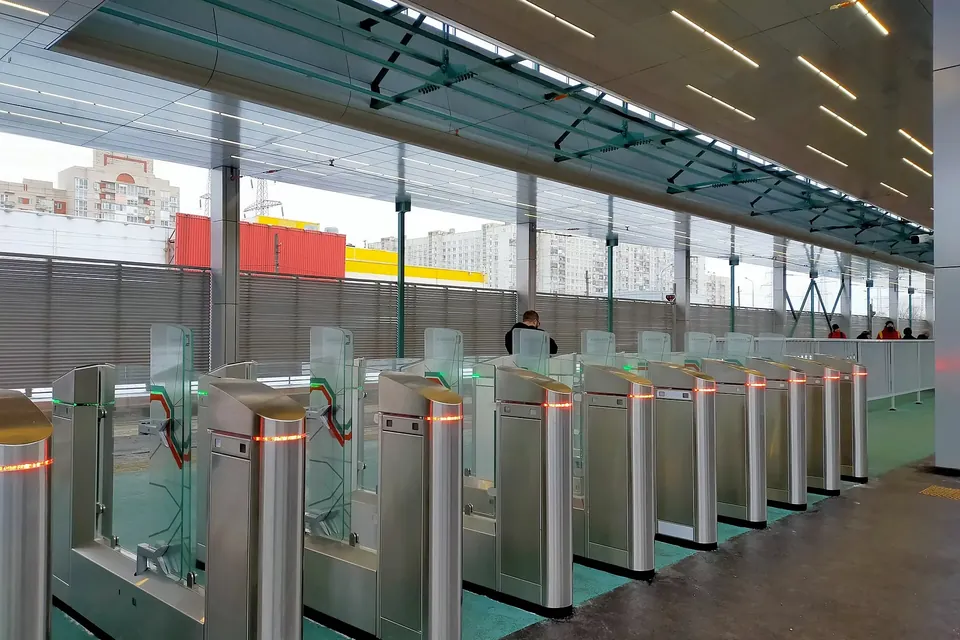 A row of glass ticket barriers at a modern tram station