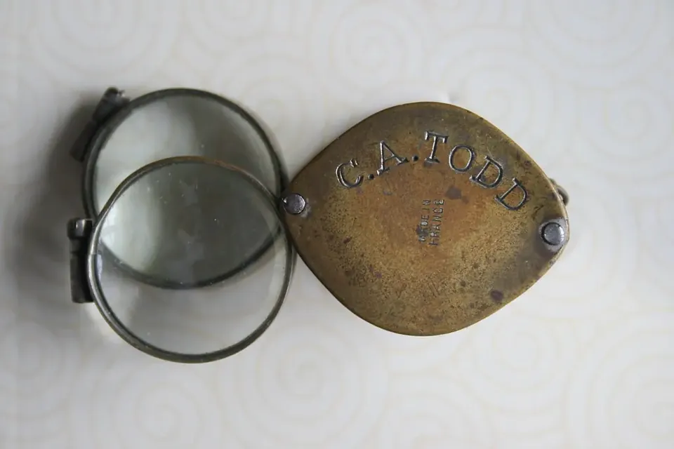 An old brass folding magnifier with two lenses, engraved C. A. Todd